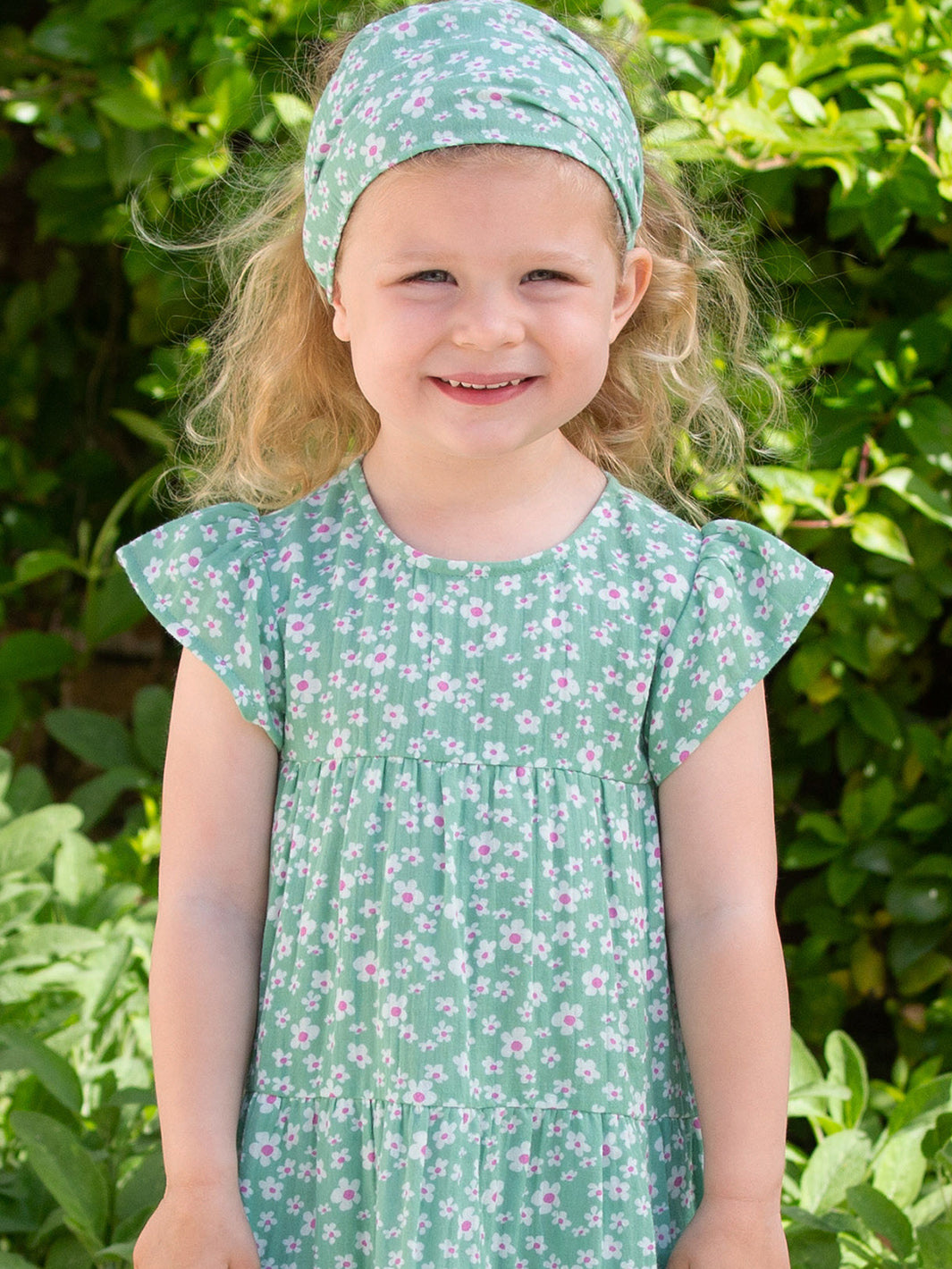 Niña usando la Bandana Pequeñas Flores de algodón orgánico, diseño floral y muselina de doble capa.