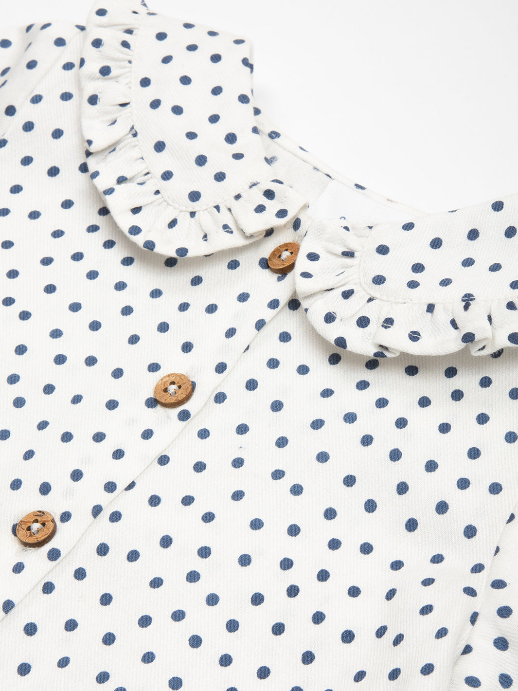 Detalle del cuello tipo muñeca con volantes en la Blusa Dolly de algodón orgánico.