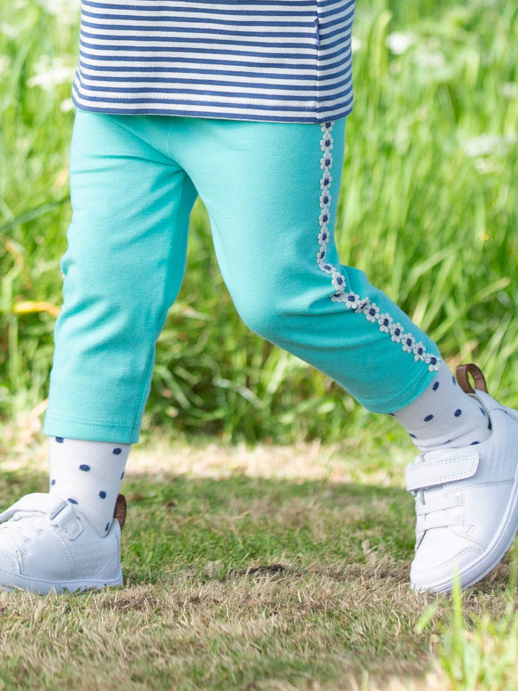 Niña usando calcetines de algodón orgánico con diseño de lunares, ideales para el día a día.