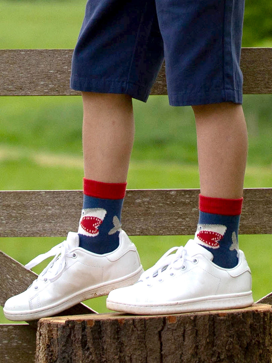 Niño usando calcetines de algodón orgánico con diseño de tiburones, perfectos para combinar con ropa infantil.