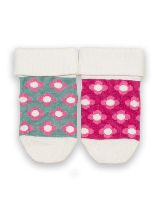 Pack de dos pares de calcetines de algodón orgánico, uno en verde abeto con estampado floral y otro en rosa con flores delicadas, ideales para mantener los pies de los más pequeños cómodos y abrigados.