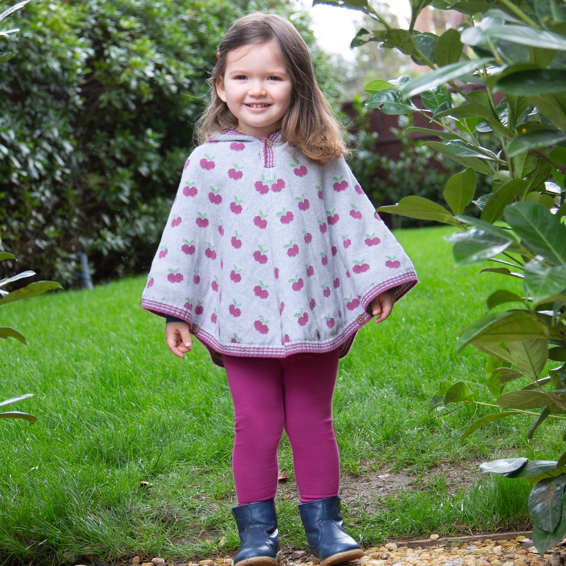 Niña usando las Calzas con Volantes de algodón orgánico, combinadas con un poncho para un look abrigado y cómodo.
