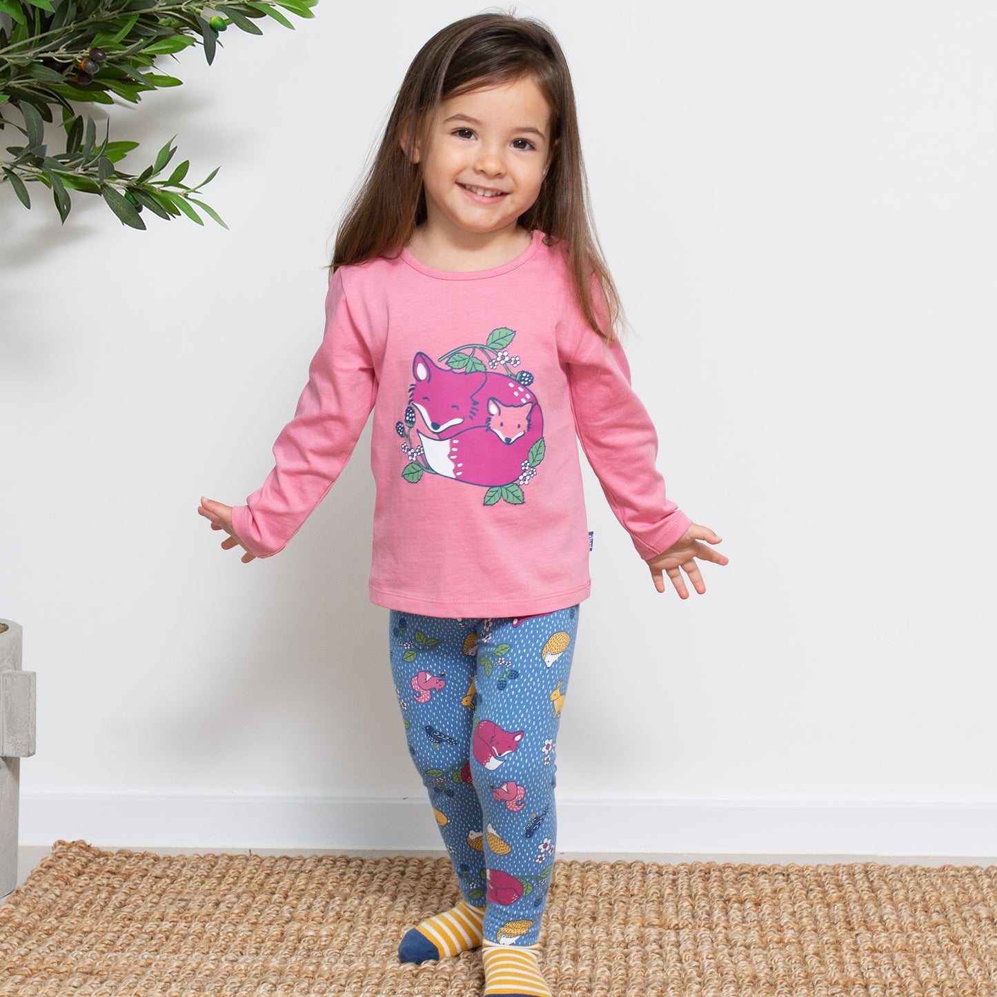 Niña vistiendo las Calzas Print de algodón orgánico con estampado de animales del bosque, look cómodo y perfecto para explorar la naturaleza.