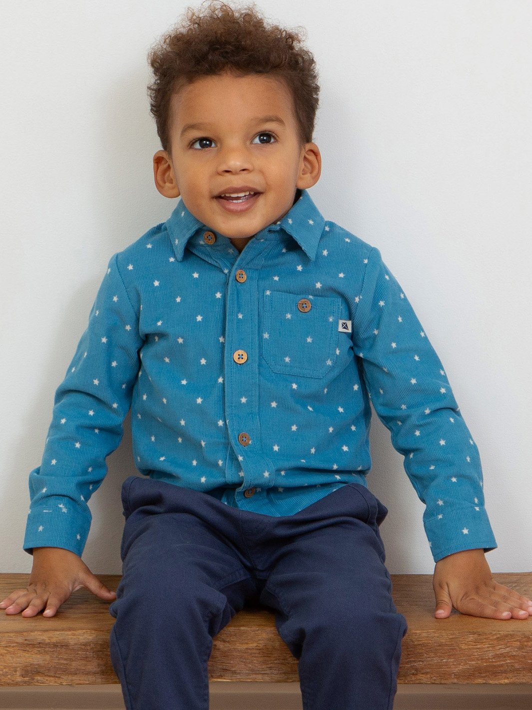 Niño vistiendo la camisa azul francés con estampado de estrellas, combinada con pantalones estilo chinos para un look moderno y sofisticado.