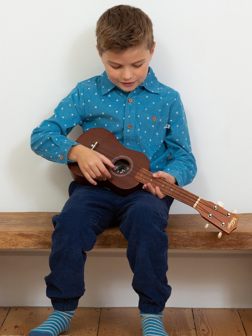 Niño vistiendo la camisa azul francés con estampado de estrellas, combinada con pantalones de cotelé para un look abrigado y sofisticado.