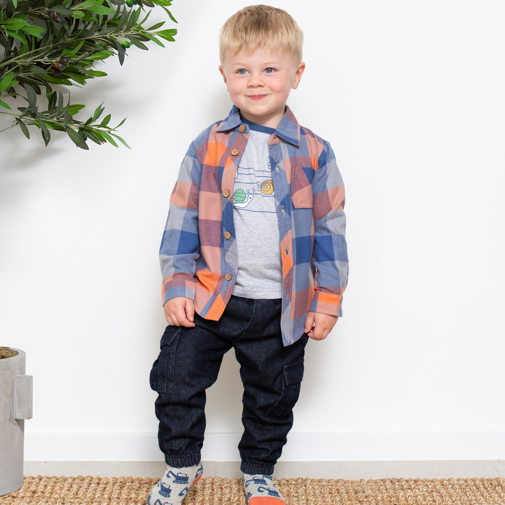 Niño vistiendo la Camisa Cuadros Cool de algodón orgánico, combinada con una camiseta para un look moderno y en capas.