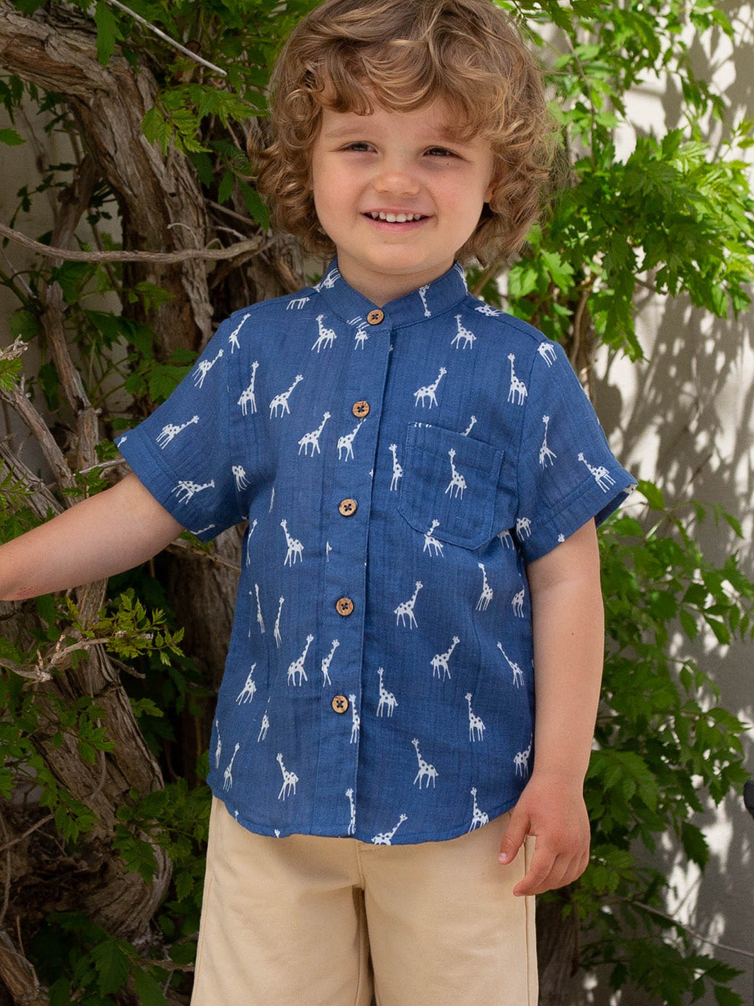 Niño vistiendo la Camisa Mao Lunares de Jirafitas de algodón orgánico, combinada con shorts yate para un look fresco y casual.
