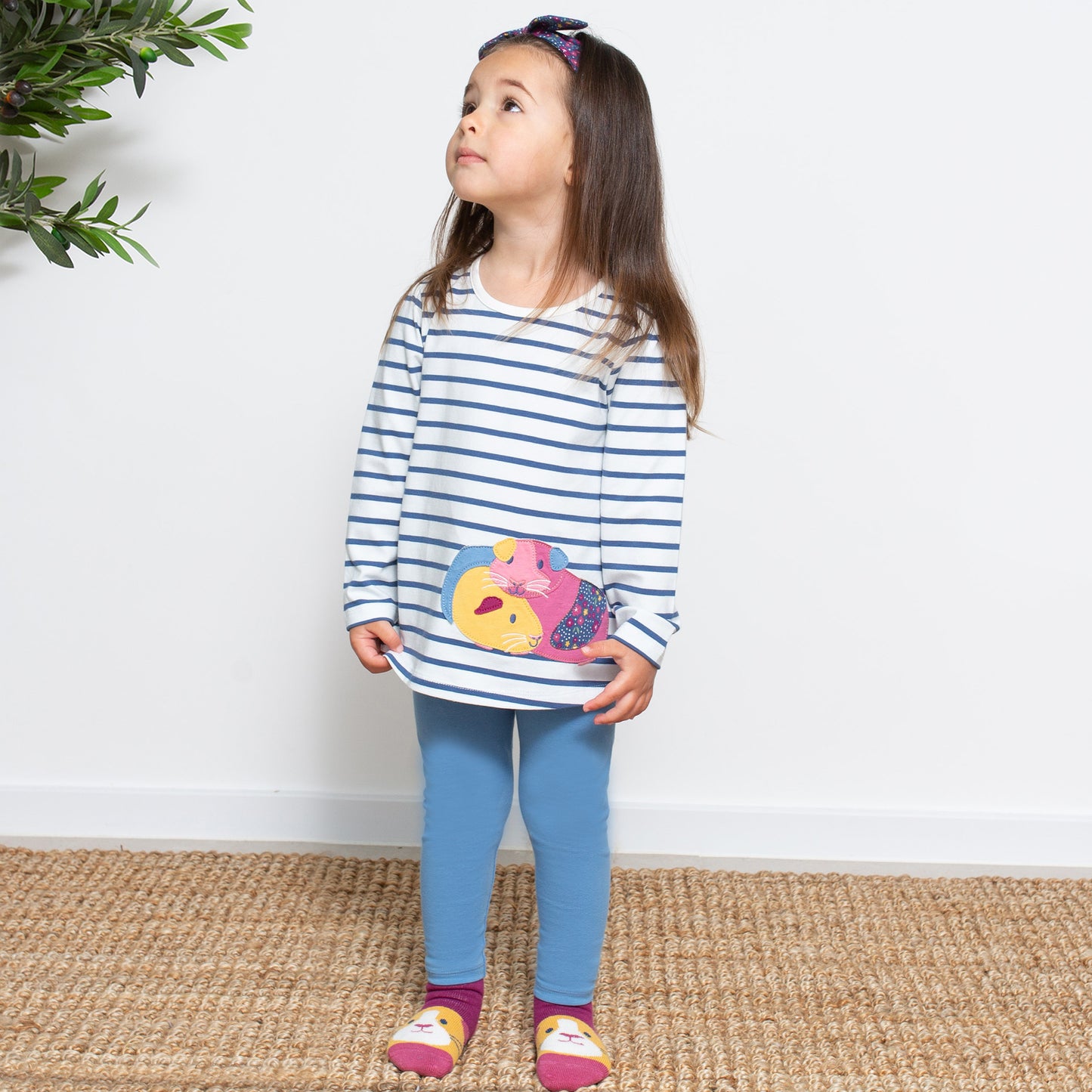 Niña con el Conjunto Conejito de algodón orgánico, con túnica de rayas y calzas celestes, ideal para cualquier ocasión.