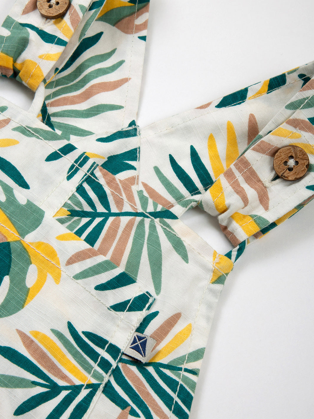 Correas ajustables con botones de coco en la Jardinera Jungla, diseño práctico y cómodo.