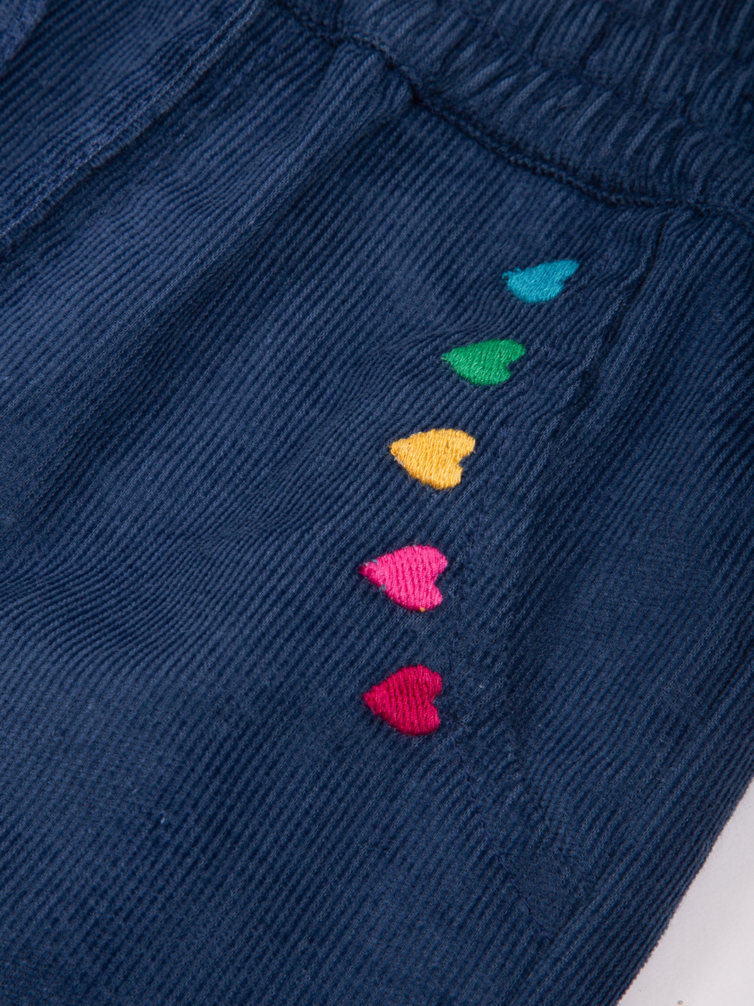 Detalle del bordado de corazones en los bolsillos del Pantalón Cotelé Corazones de algodón orgánico, diseño encantador y ecológico.