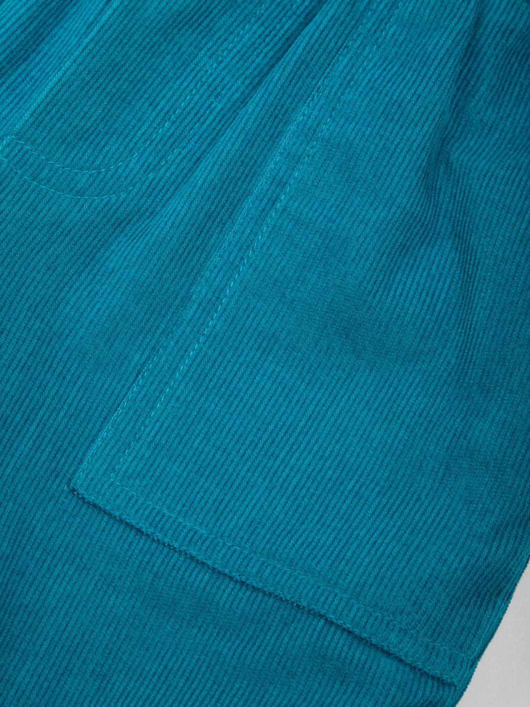 Detalle de los bolsillos tipo parche en el Pantalón Cotelé Puños de algodón orgánico, diseño funcional y moderno.