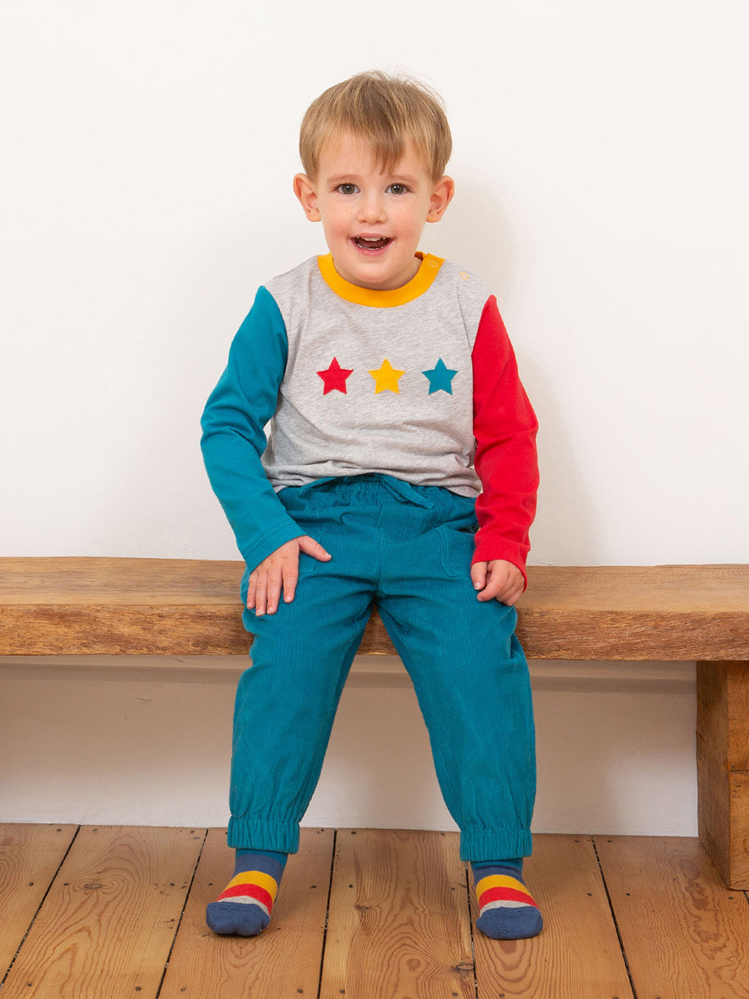 Niño usando el Pantalón Cotelé Puños de algodón orgánico, perfecto para un look casual y abrigador.