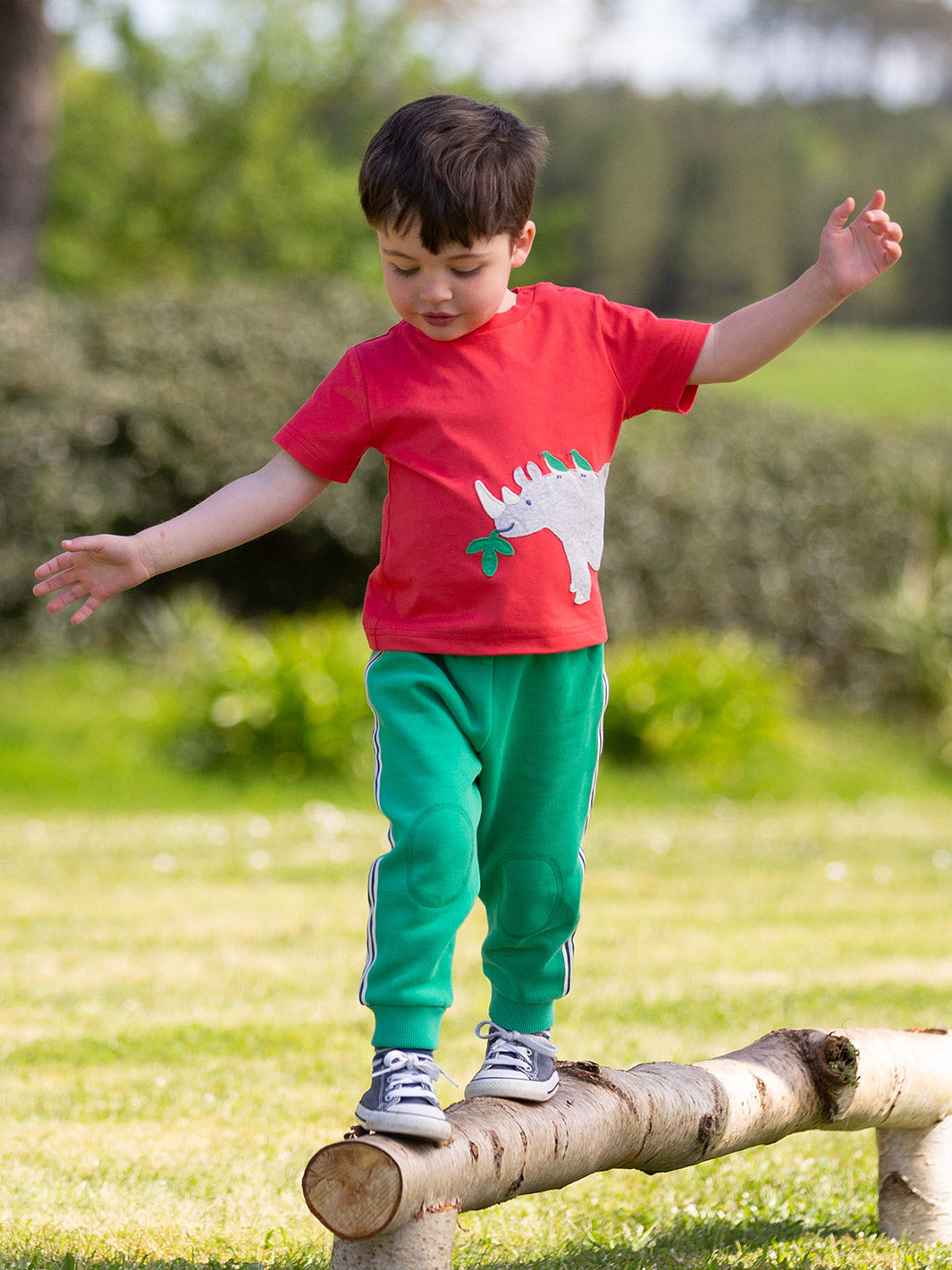 Niño usando la Polera Amigos Rinocerontes de algodón orgánico, combinada con pantalón para un look casual y cómodo.