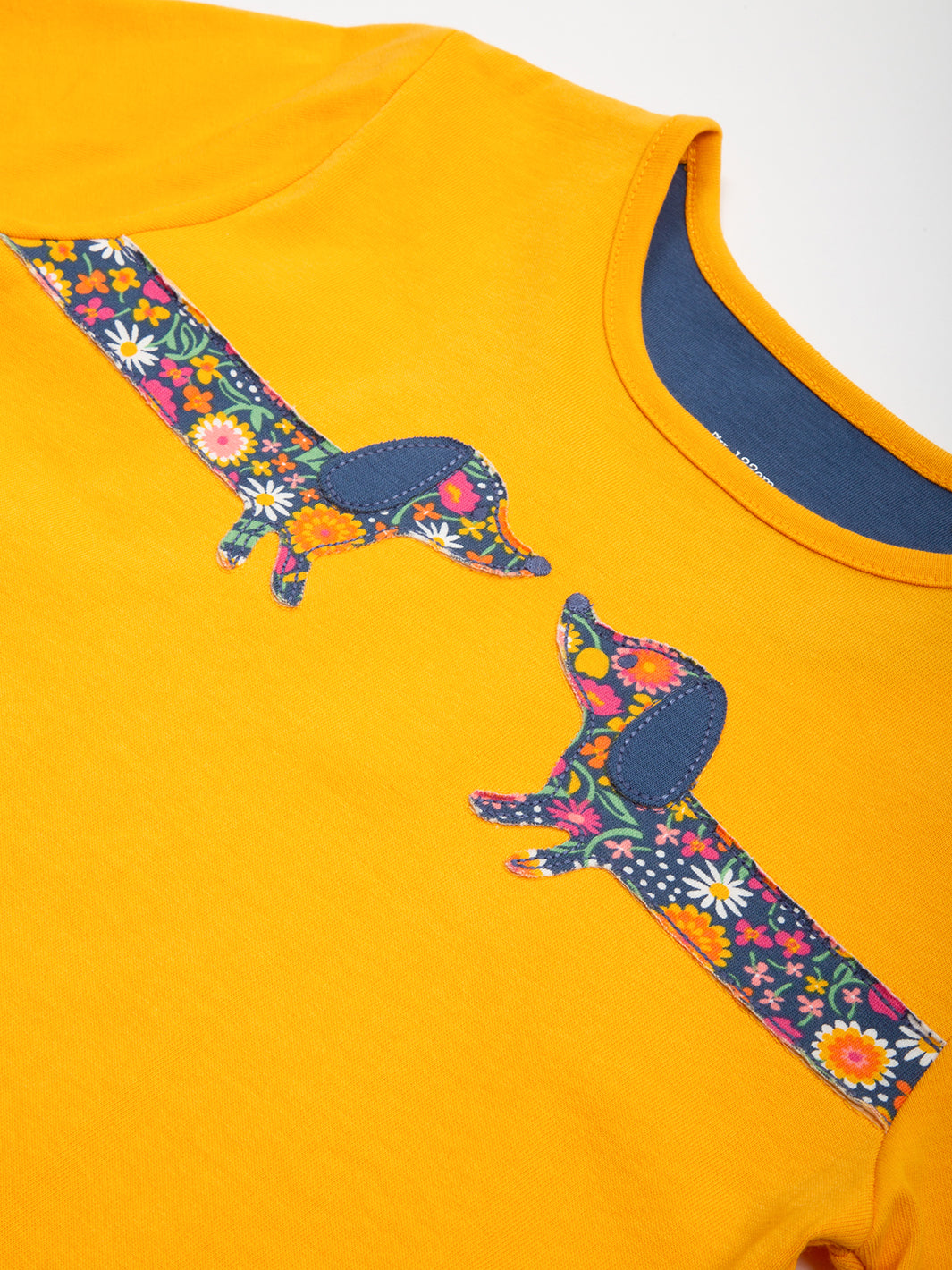 Detalle del aplique de perro salchicha en la Polera Amigos Salchichas de algodón orgánico, certificado GOTS y OEKO-TEX.