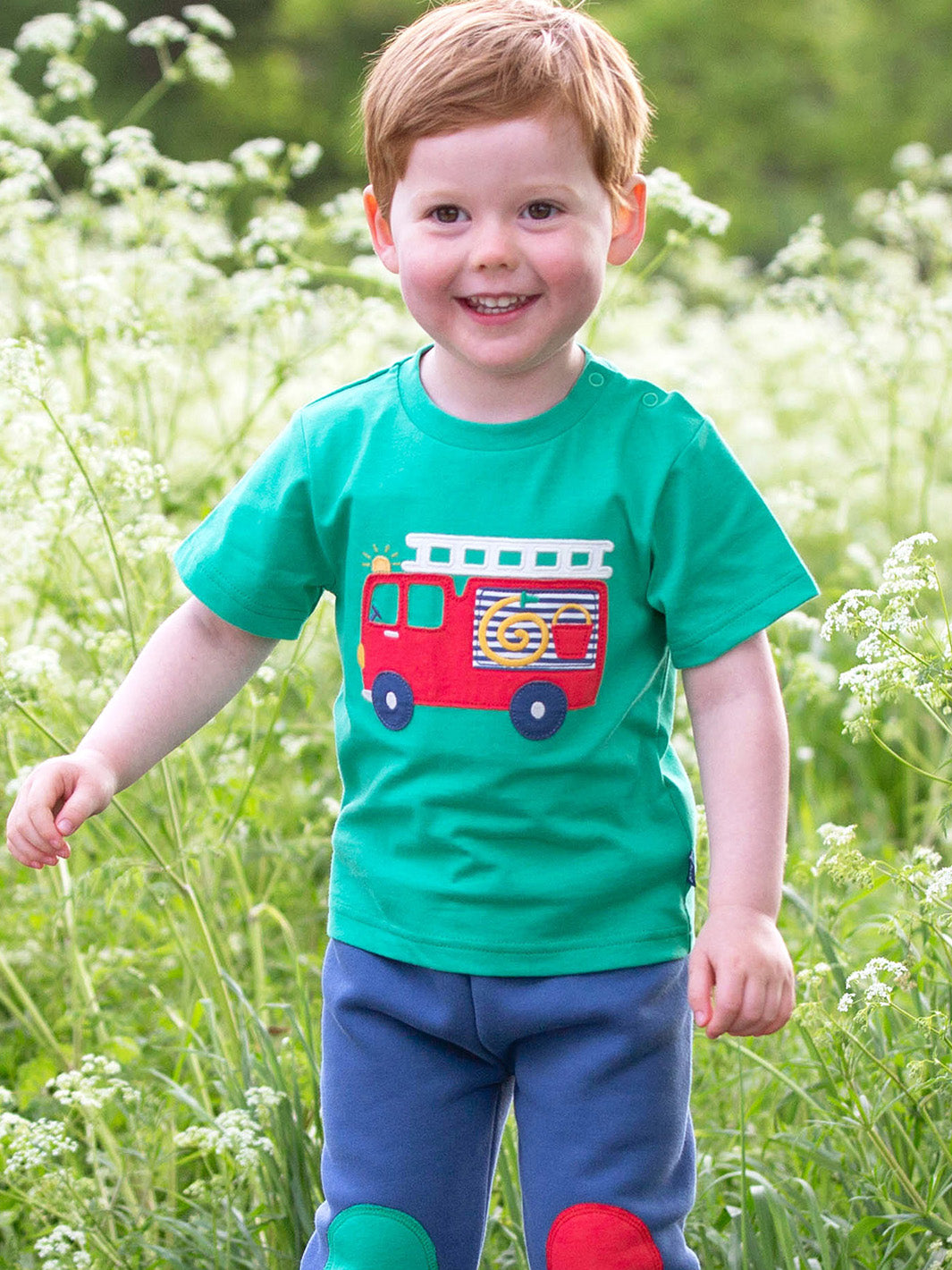 Niño usando la Polera Carro Bomba de algodón orgánico, ideal para pequeños héroes.