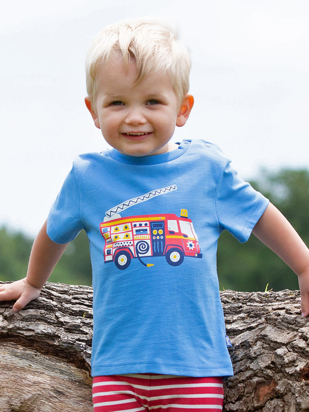 Niño vistiendo la Polera Carro Bomba de algodón orgánico, ideal para pequeños héroes.