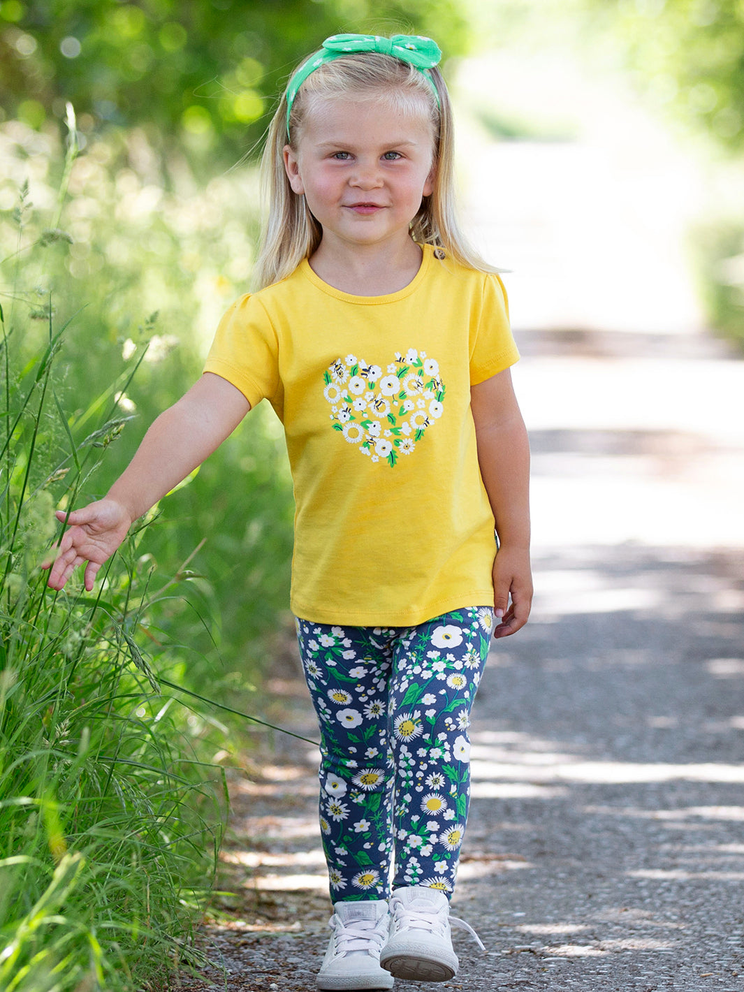 Niña usando la Polera Corazón Floral de algodón orgánico, combinada con calzas estampadas.