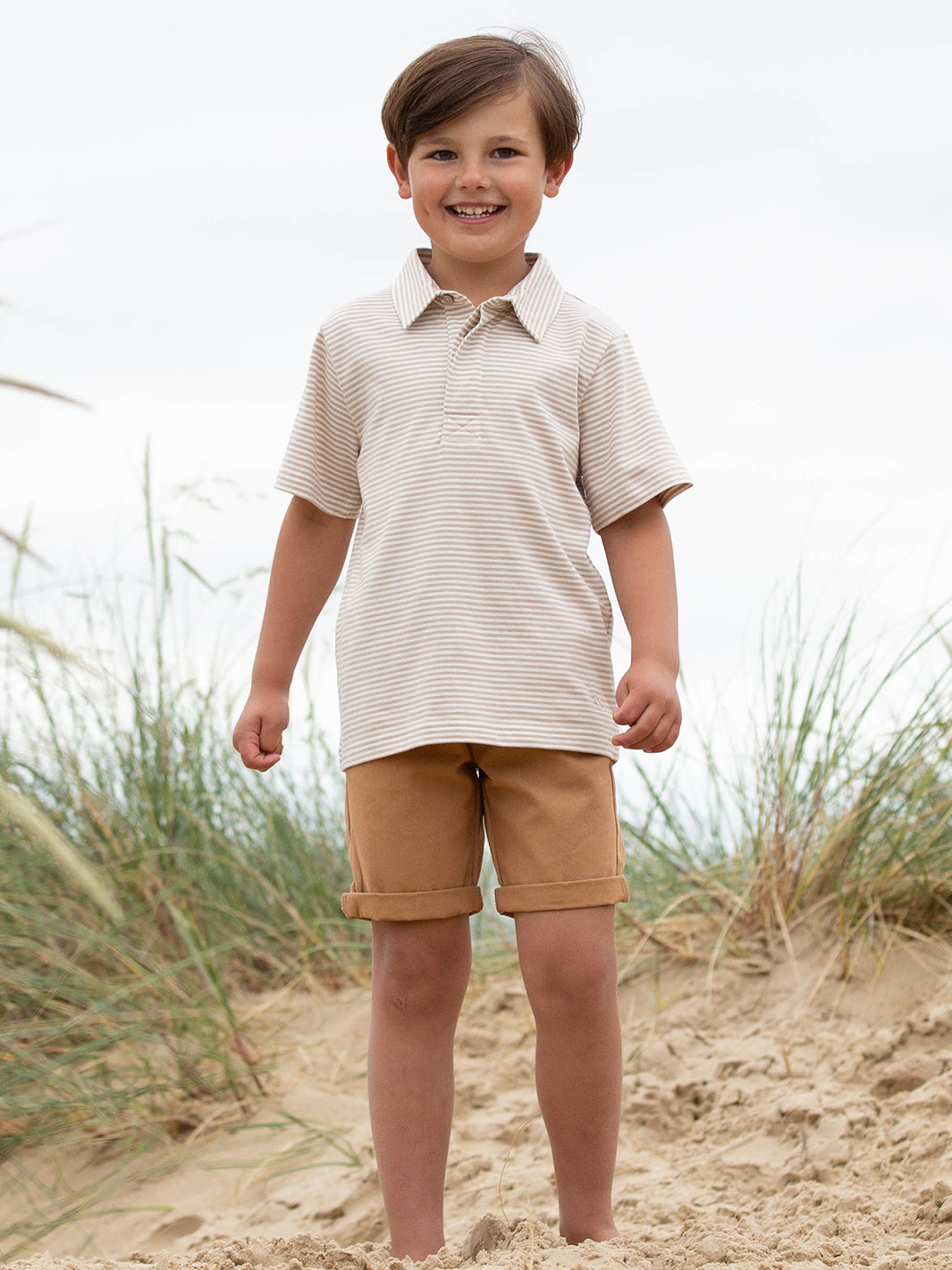 Niño usando la Polera Cuello Polo de algodón orgánico, combinada con short para un look casual y elegante.