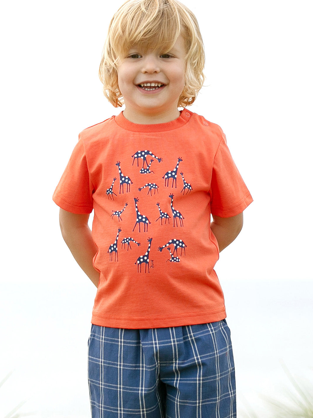 Niño usando la Polera Jirafitas de algodón orgánico, combinada con shorts para un look fresco y veraniego