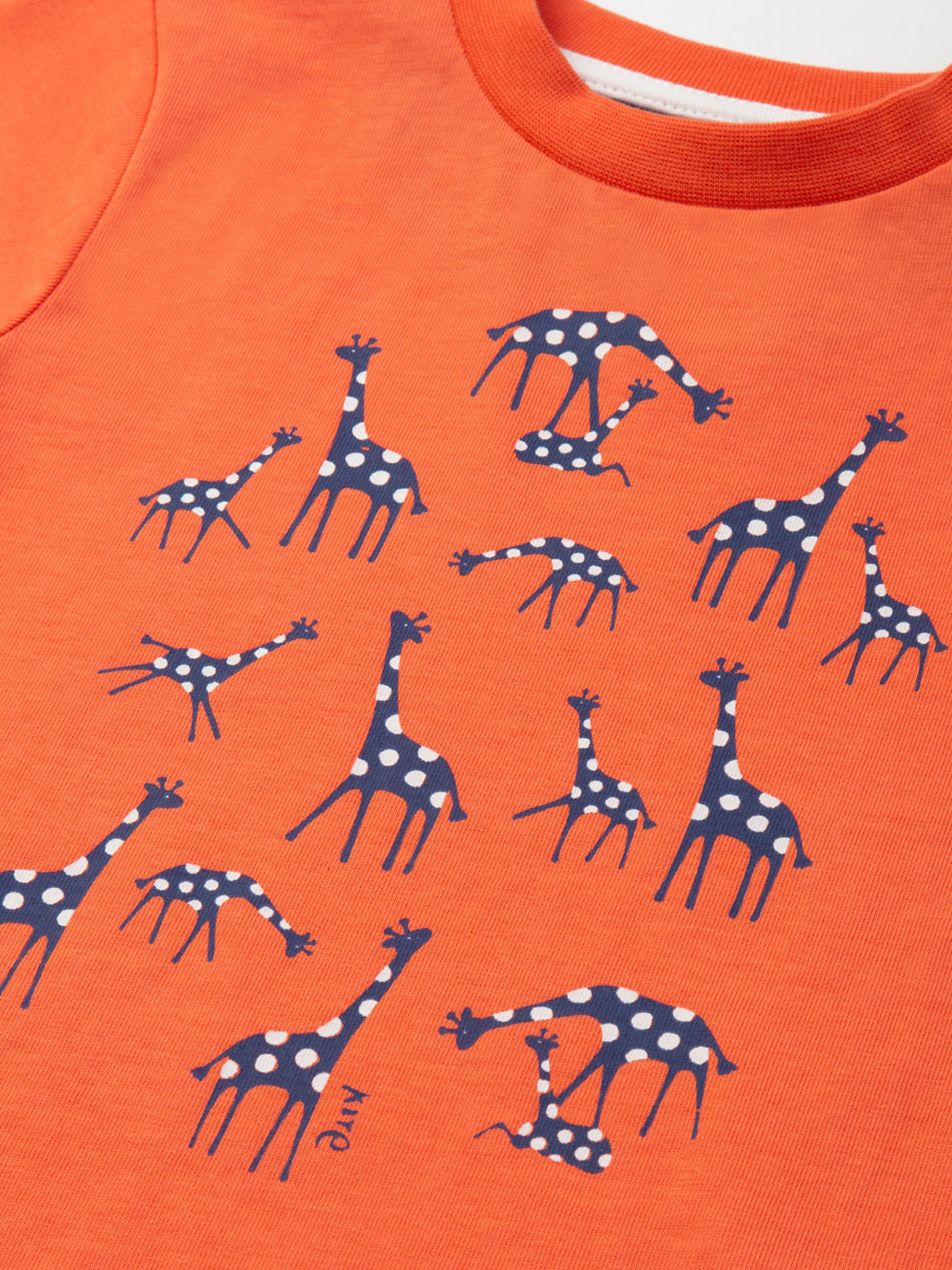 Detalle del estampado de jirafas en la Polera Jirafitas de algodón orgánico, diseño divertido y ecológico.