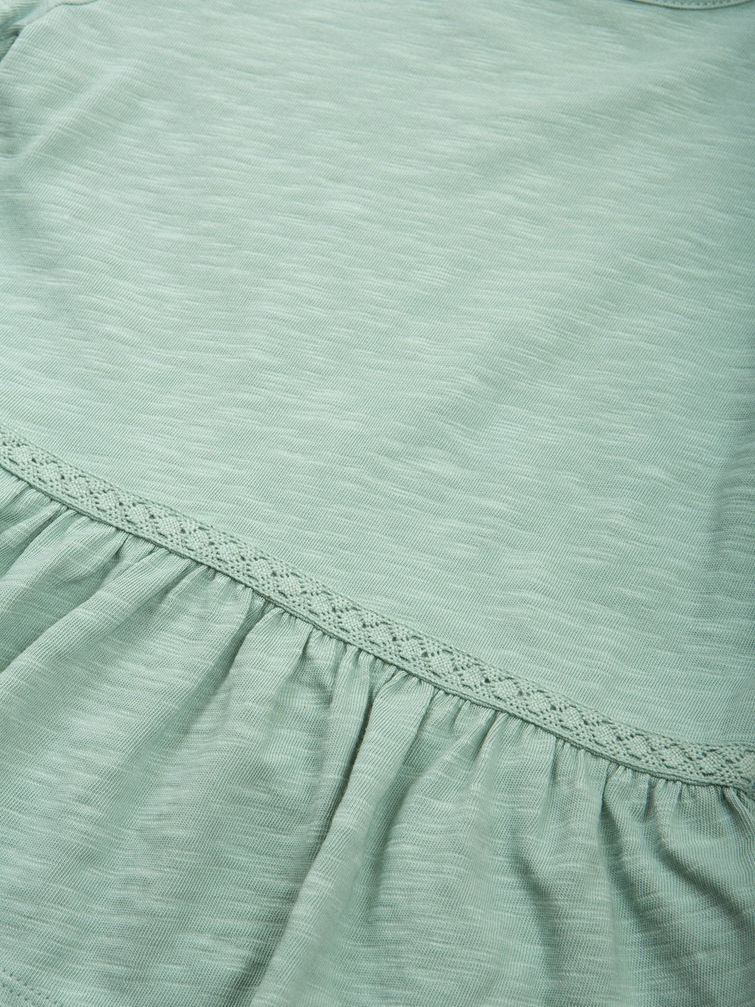 Primer plano del inserto de encaje de algodón, con suaves pliegues que aportan un toque delicado y elegante al diseño.
