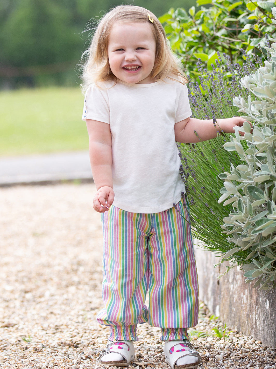 Niña usando la Polera Margaritas de algodón orgánico, combinada con pantalones para un look fresco y encantador.