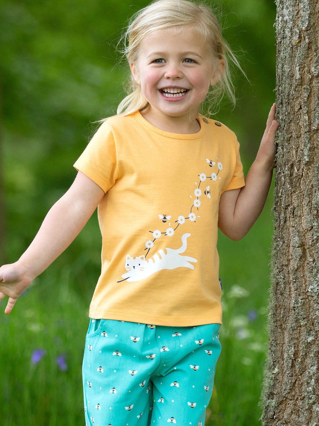 Niña usando la Polera Pequeño Gatito de algodón orgánico, combinada con calzas para un look fresco y adorable.