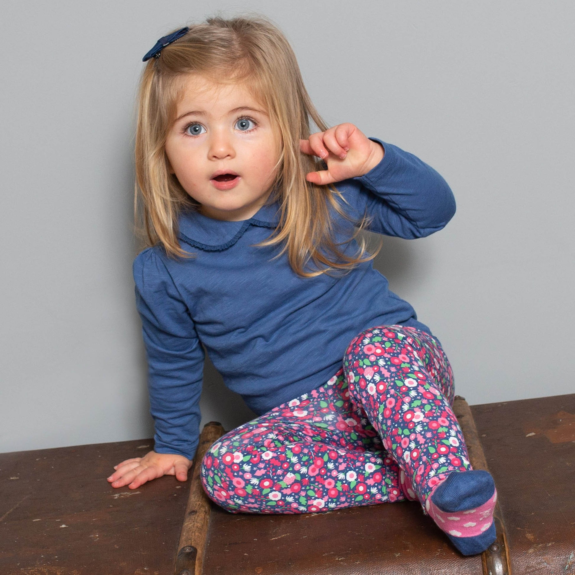 Niña vistiendo la Polera Peter Pan de algodón orgánico, combinada con una calza para un estilo clásico y femenino."