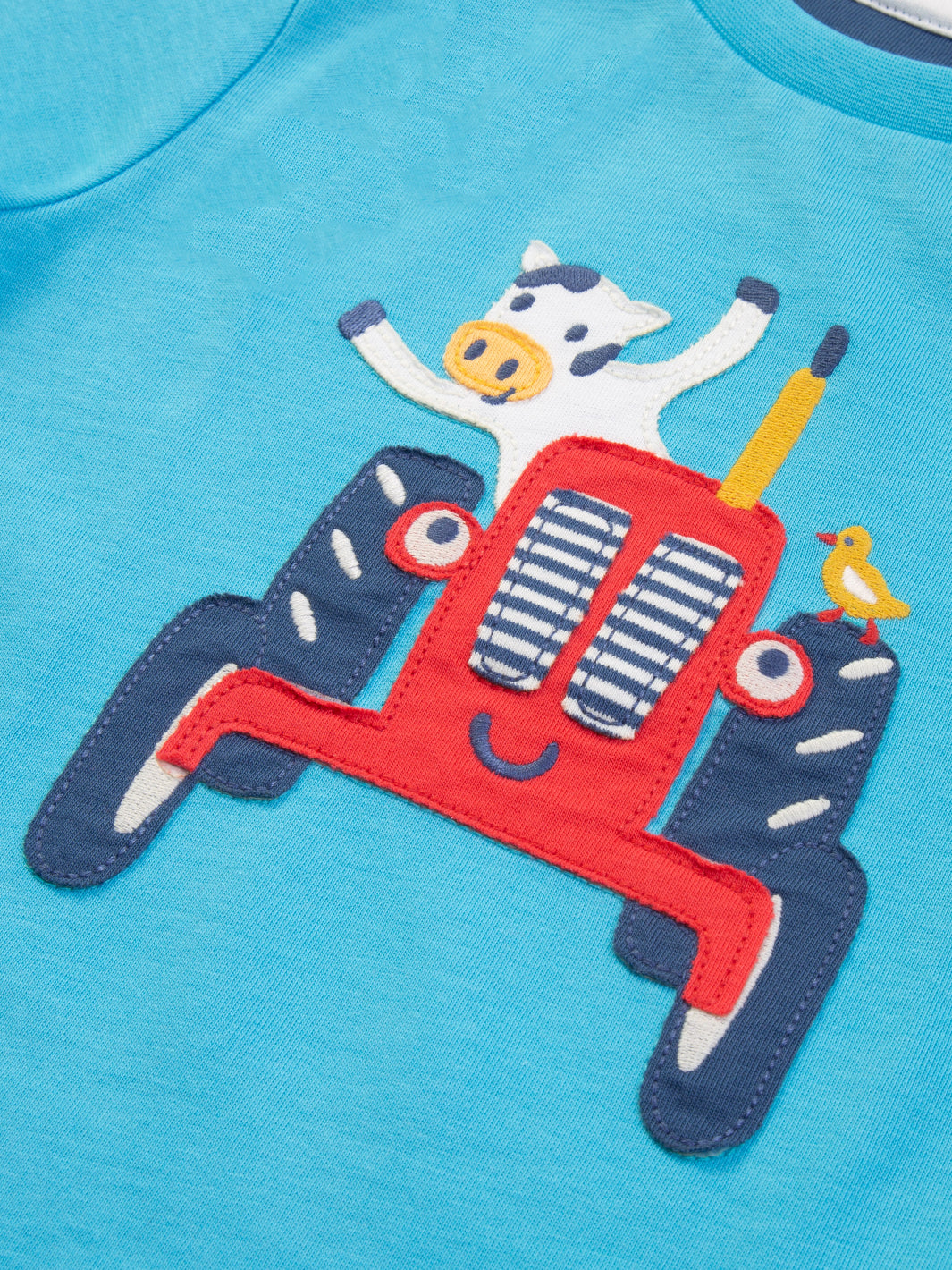Detalle del aplique de tractor y vaca en la Polera Vaca Tractorista de algodón orgánico, diseño entretenido y ecológico.
