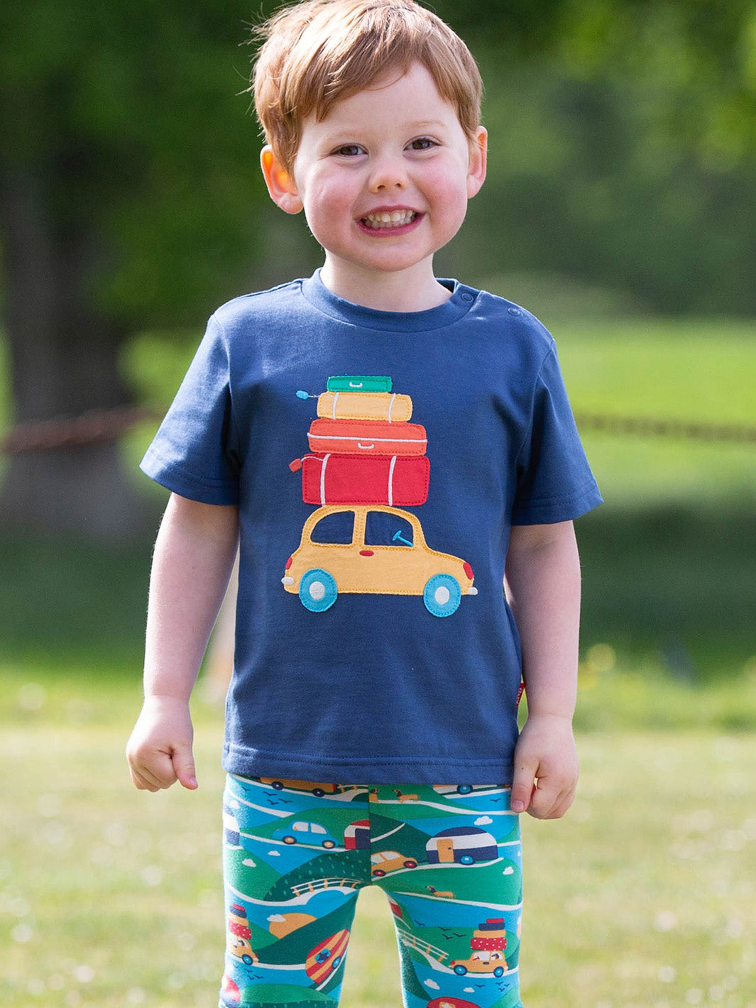 Niño usando la Polera Vacaciones de algodón orgánico, combinada con shorts para un look fresco y aventurero.