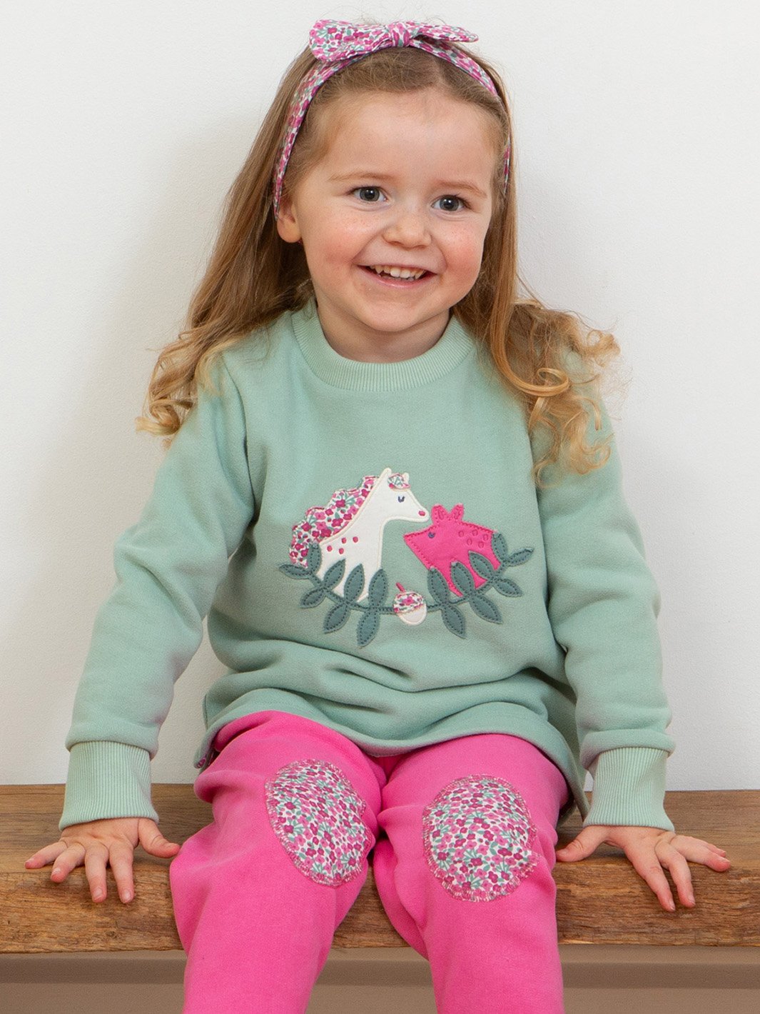 Niña vistiendo el polerón amigo cerdito con un look casual y acogedor, combinado con pantalones de buzo