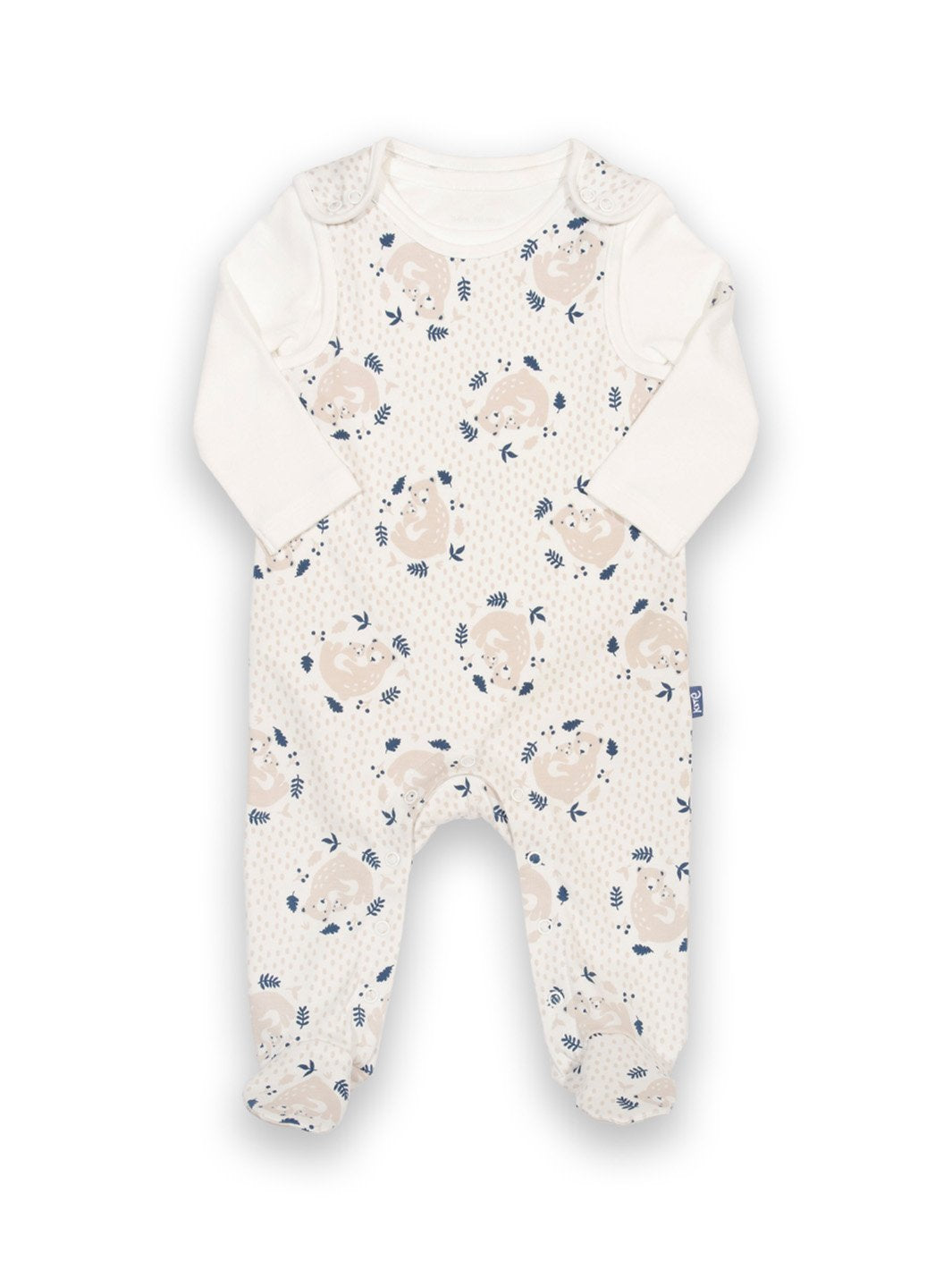 Conjunto de algodón orgánico para bebé, compuesto por una jardinera con estampado de osito abrazable y un body color crema con cuello envolvente y bordado de oso en el brazo.