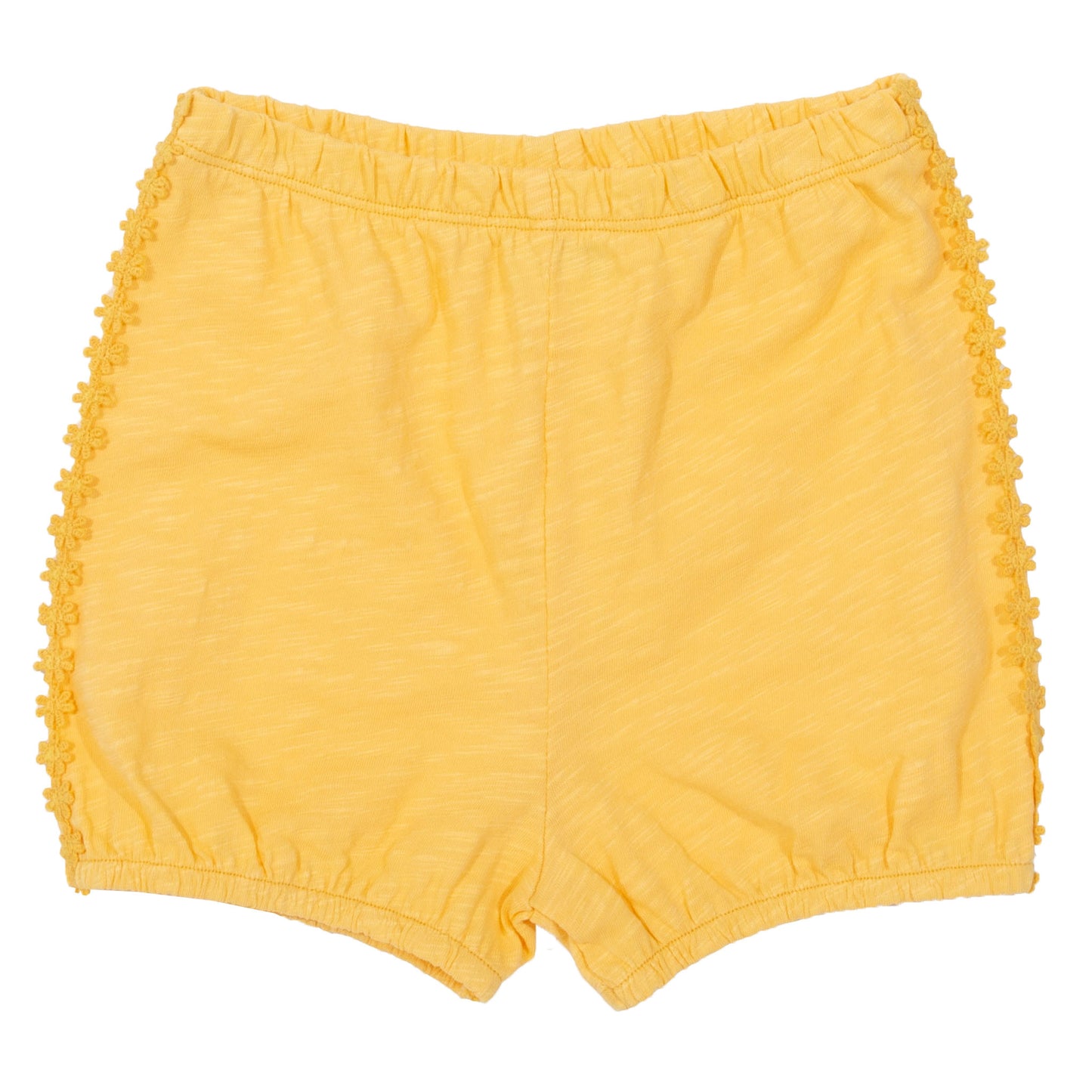 Short Burbuja de algodón orgánico, color amarillo con ribete de margaritas y forma abullonada.