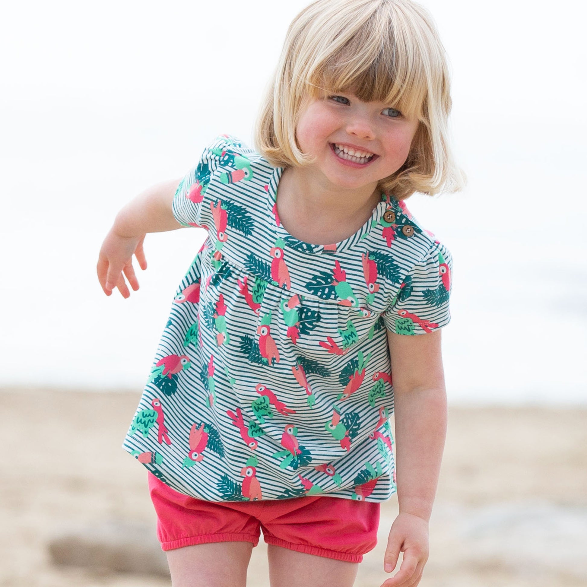 Niña usando el Short Burbuja rojo, de algodón orgánico, combinado con una polera para un look fresco y veraniego.