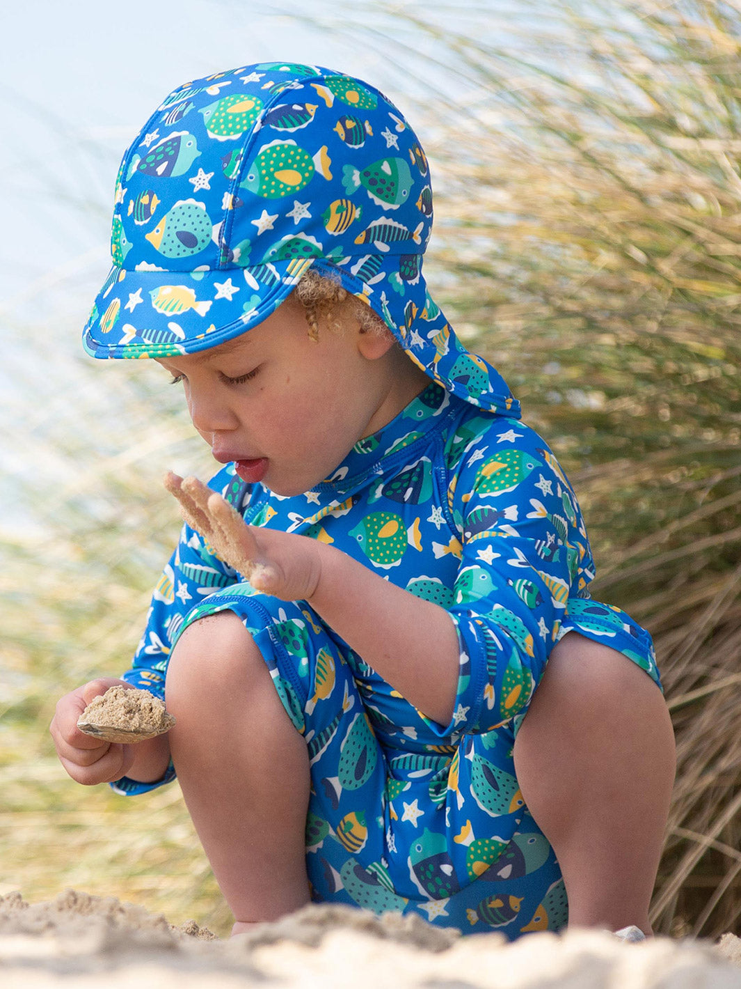 Pequeño disfrutando del sol con un sombrero de protección UV, diseño legionario en tela ligera reciclada y certificada.