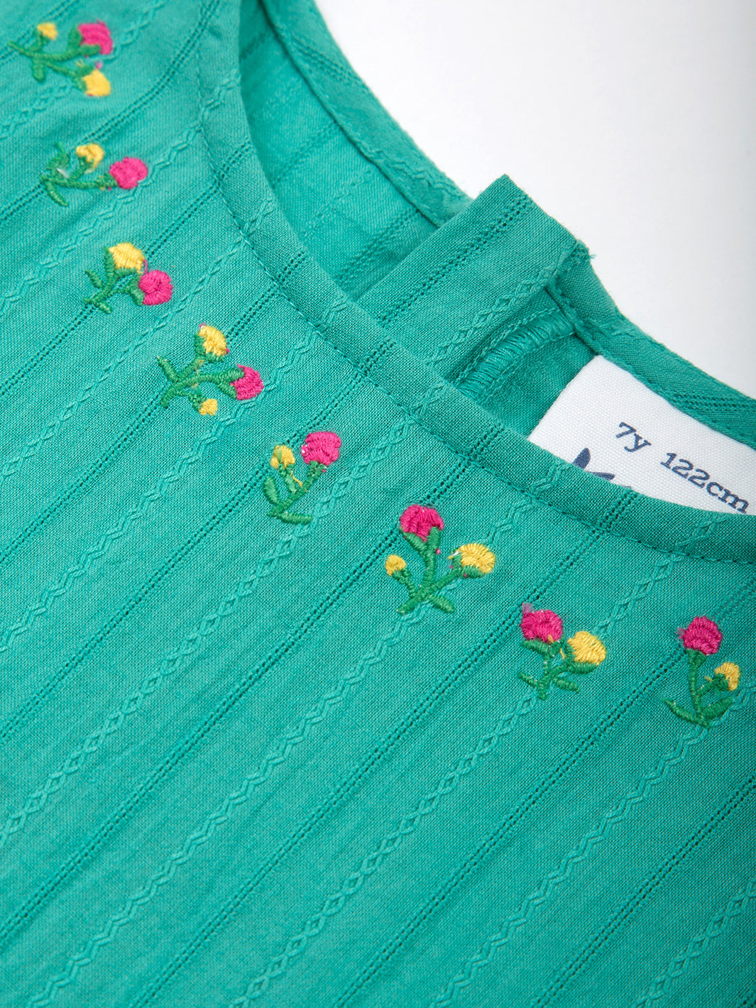 Detalle del bordado floral en el cuello del Vestido Cascada, diseño delicado y femenino.