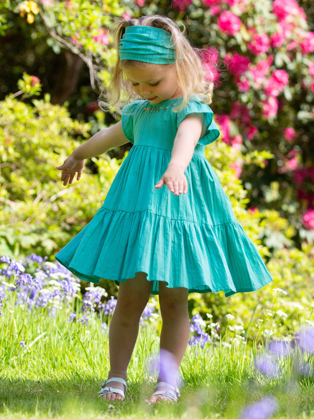Niña usando el Vestido Cascada de algodón orgánico, combinado con la bandana Cascada para un look completo.