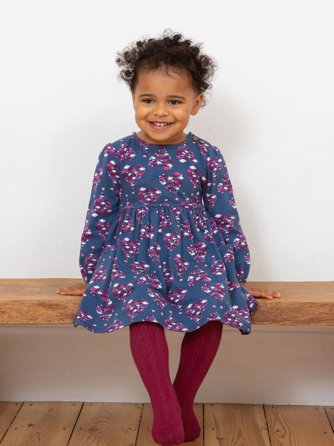 Niña usando el Vestido Dulce Hogar de algodón orgánico, look cómodo y encantador para cualquier ocasión.