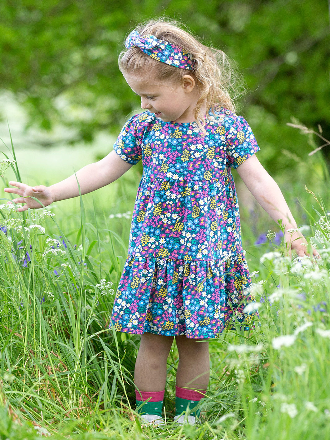 Niña usando el Vestido Jardín de Flores de algodón orgánico, look fresco y cómodo para el verano.