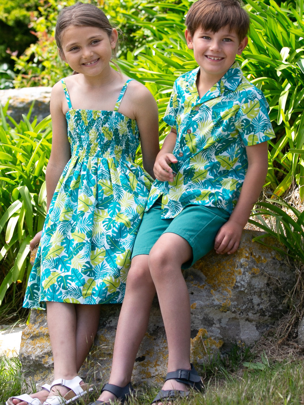 Niña vistiendo el Vestido Jungla de algodón orgánico con estampado tropical, ideal para días soleados y aventuras al aire libre.