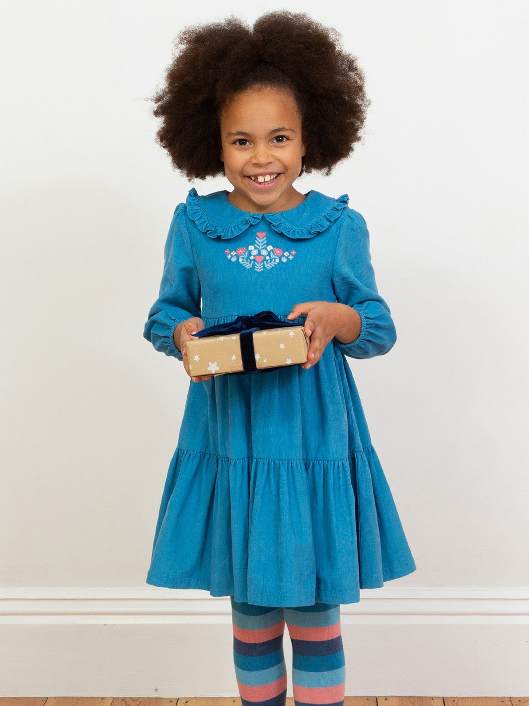 Niña mostrando el vestido azul francés de manga larga, cómodo y elegante, útil para toda ocasión