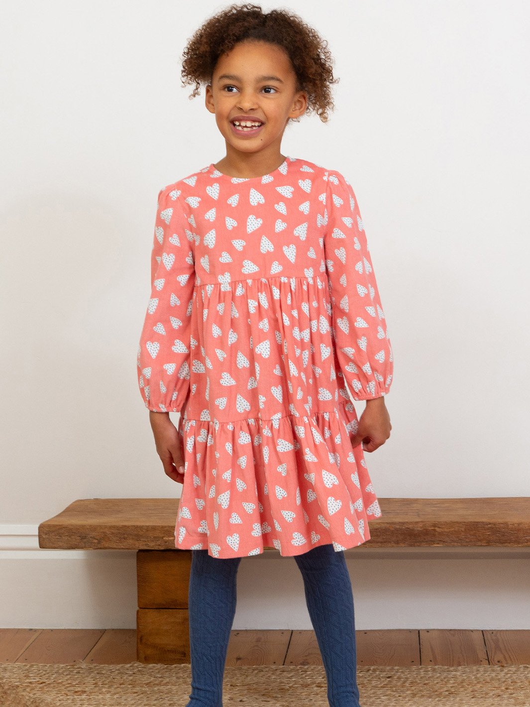 Niña vistiendo el vestido de manga larga Te Quiero, mostrando su diseño romántico con falda de volantes, combinada con pantys para un look abrigado y femenino