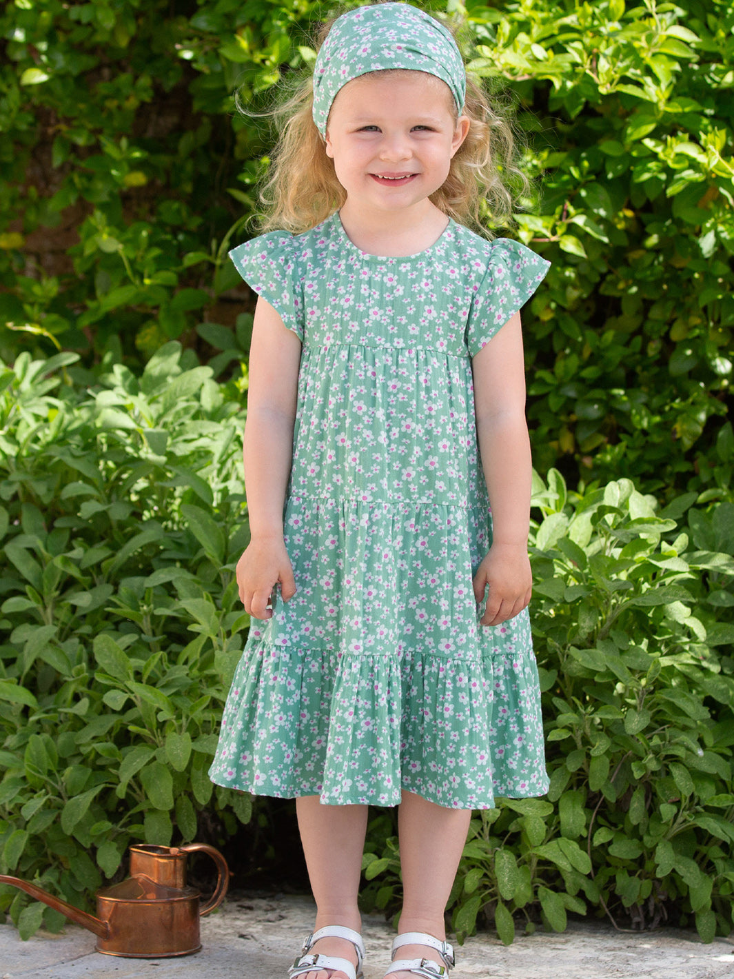 Niña usando el Vestido Pequeñas Flores de algodón orgánico, look delicado y fresco para cualquier ocasión.