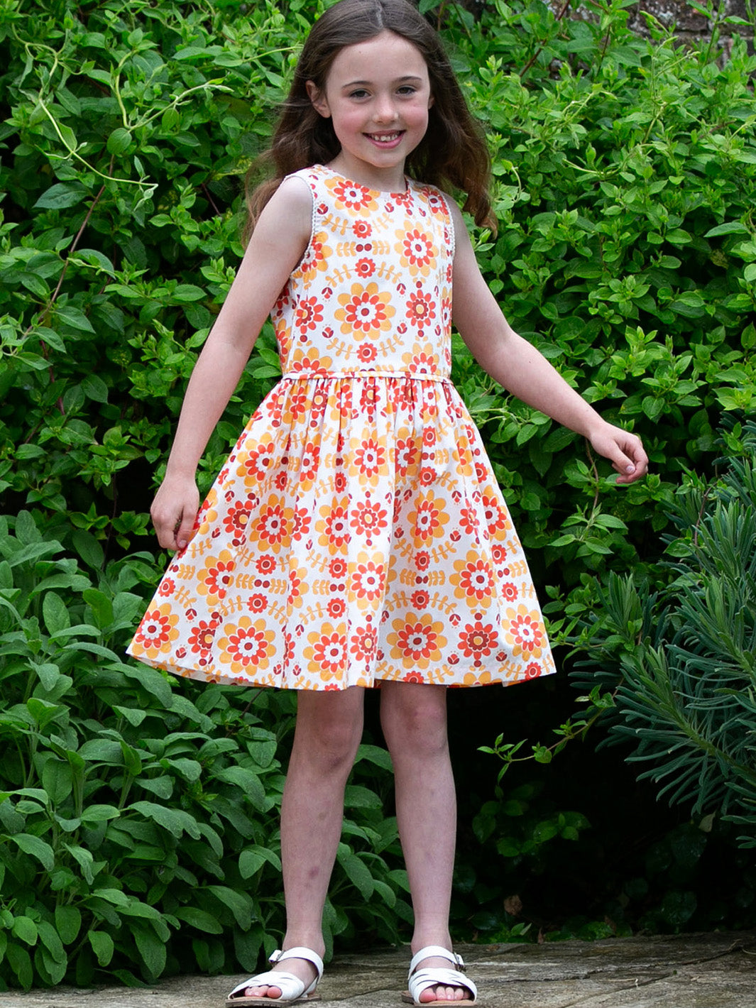 Niña vistiendo el Vestido Retro de algodón orgánico, disfrutando de su diseño vintage con estampado floral y su estilo liviano para el verano.