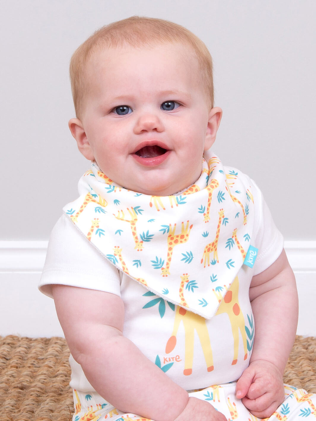 Guagua usando babero hola jirafa en algodón orgánico, ropa infantil sustentable Chile.