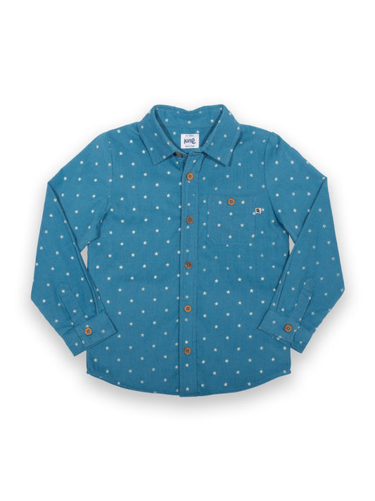 Camisa de algodón orgánico en tono azul francés con estampado de estrellas, cuello clásico, bolsillo en el pecho y botones de coco, perfecta para un look elegante y cómodo.