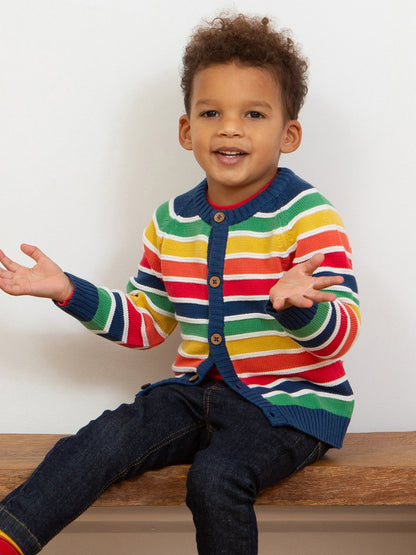 Niño usando el chaleco tejido arcoíris, destacando su ajuste cómodo, tejido de punto suave y vibrante combinación de colores.