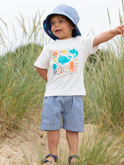 Niño vistiendo el Conjunto Bajo el Mar de algodón orgánico, look fresco y cómodo para días de playa y sol.