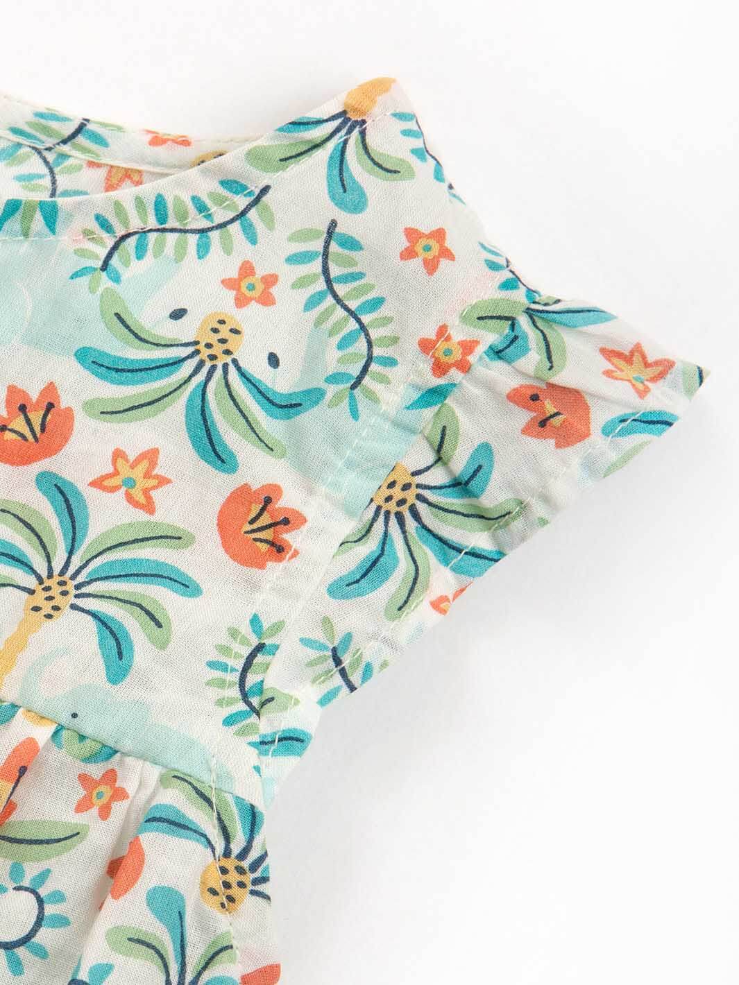 Detalle de la tela y diseño tropical del enterito sin mangas para bebé en algodón orgánico.