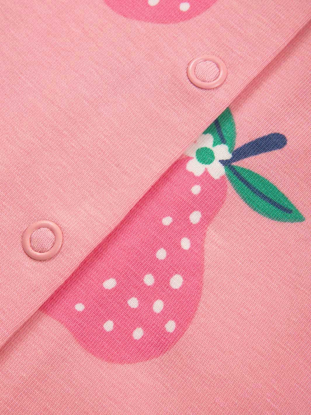 Detalle de botones y estampado de peras en pijama rosa orgánico para bebé